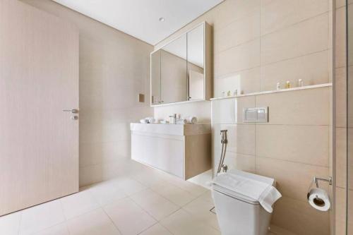 a white bathroom with a toilet and a sink at Burj Royale - Burj Khalifa View - 4m Walk to Dubai Mall in Dubai