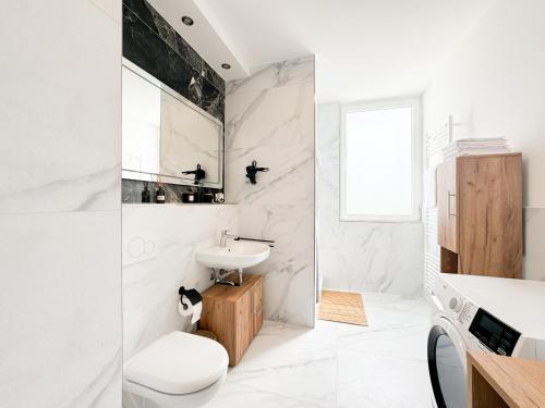 a white bathroom with a sink and a toilet at Lifestyle Penthouse Apartment in Ludwigshafen am Rhein