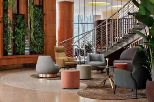a lobby with chairs and tables and a staircase at The Westin Warsaw in Warsaw