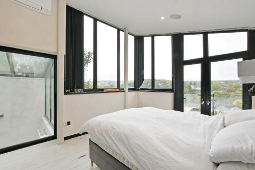 Schlafzimmer mit einem großen weißen Bett und Fenstern in der Unterkunft West View 3 Bedroom Villa With Hot Tub in Heeley