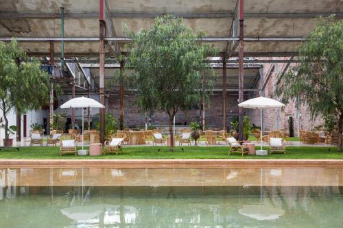 a pool of water with chairs and umbrellas at Hotel Hércules in Querétaro