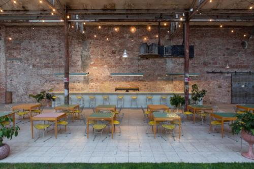 a restaurant with tables and chairs in a brick wall at Hotel Hércules in Querétaro