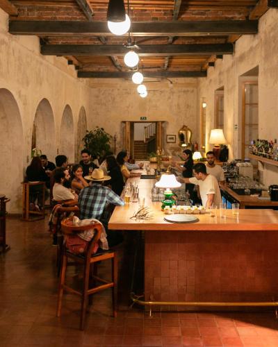 a group of people sitting at a bar in a restaurant at Hotel Hércules in Querétaro