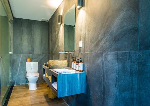 a bathroom with a blue sink and a toilet at Ba Ho Eco Beat in Ninh Hòa