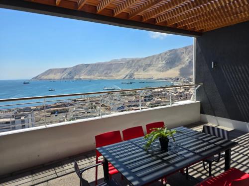 una mesa y sillas en un balcón con vistas al océano en Edificio Lynch Centrico - entrego FACTURA, en Iquique