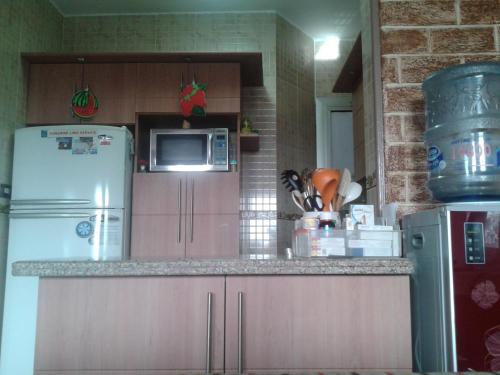 een keuken met een koelkast en een magnetron bij شقة أرضي بحديقه بكمبوند راقي بالعبور in ‘Ezbet el-Insha