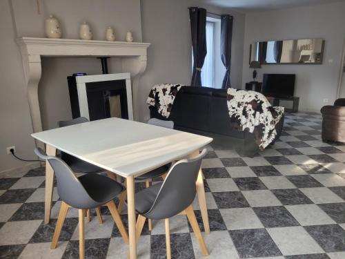 - une table et des chaises dans le salon doté d'une cheminée dans l'établissement La Cadole, à Baroville