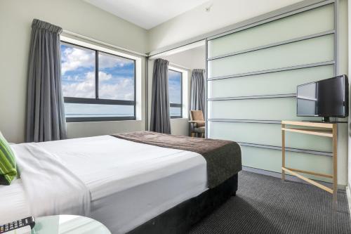 a hotel room with a bed and a tv at 18th Floor Seaview Exec Style King Bed Apartment in Darwin