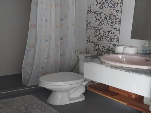 a bathroom with a white toilet and a sink at Oceanside Place in Rayong