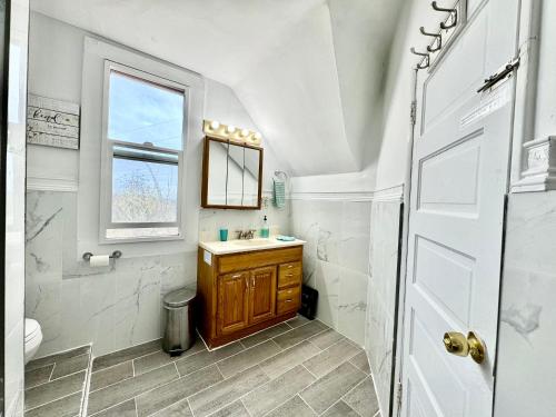 La salle de bains est pourvue d'un lavabo, de toilettes et d'une fenêtre. dans l'établissement Tiny Private Room on the 1st Floor Shared Bathroom near Airport and Downtown Seattle, à Seattle