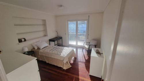 een kleine slaapkamer met een bed en een raam bij Apartamento Sonho Azores T5 in Ponta Delgada