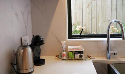a kitchen counter with a coffee maker and a sink at W&M Orchid House in Auckland