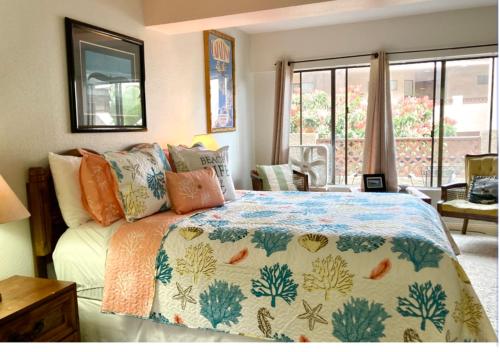 ein Schlafzimmer mit einem Bett mit einer bunten Bettdecke in der Unterkunft Catalina's Got Cart Condo in Avalon