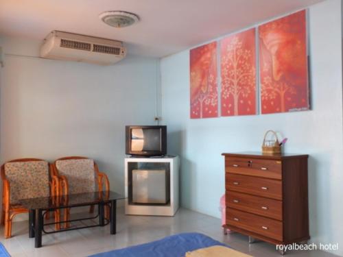 a living room with a tv and a table and chairs at Royal Beach Guest House in Hua Hin