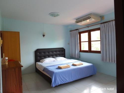 a bedroom with a bed with two towels on it at Royal Beach Guest House in Hua Hin