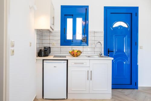 una cocina con armarios azules y fregadero en Corali Studios, en Lefkos Karpathou