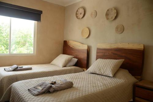 a bedroom with two beds with towels on them at Casa Parota Manzanillo in Manzanillo