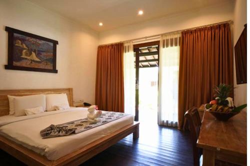 Un dormitorio con una cama grande y una ventana. en Sidesratra 1 BR Classic Superior NE56, en Gili Air
