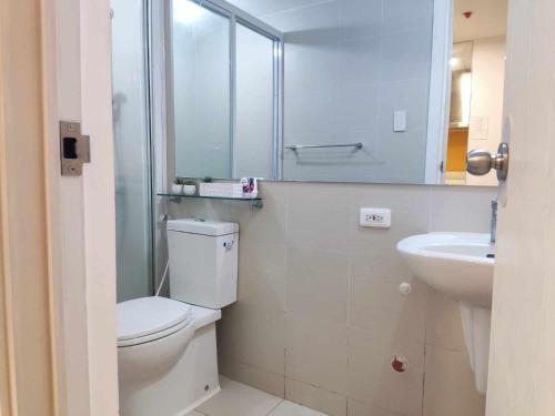 a bathroom with a white toilet and a sink at Happy Modern Studio in Azure in Lagundi