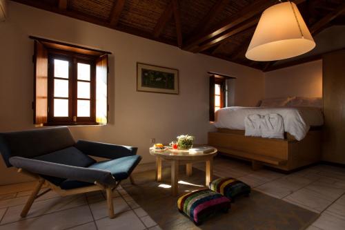 una camera con letto, sedia e tavolo di House in the Castle a Monemvasía