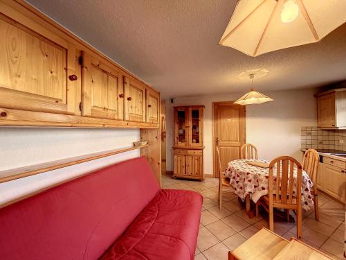 un salon avec un canapé rouge et une table dans l'établissement Charmant 3 pièces avec jardin, parking et proximité ski bus à 900m du village de Combloux - FR-1-560-121, à Combloux