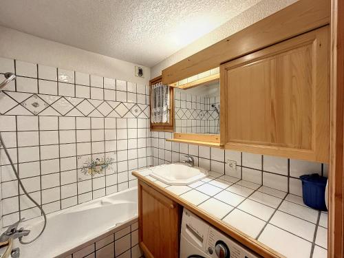 une salle de bain avec une baignoire et un lavabo et une baignoire dans l'établissement Charmant 3 pièces avec jardin, parking et proximité ski bus à 900m du village de Combloux - FR-1-560-121, à Combloux