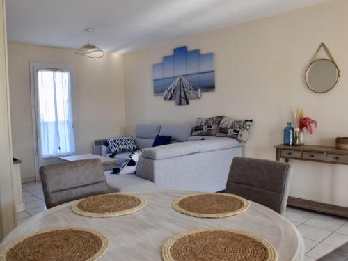 un salon avec une table et un canapé dans l'établissement Maison moderne 4 pers près du phare de Chassiron avec jardin clos, wifi, et proche plage - FR-1-778-21, à Saint-Denis-dʼOléron