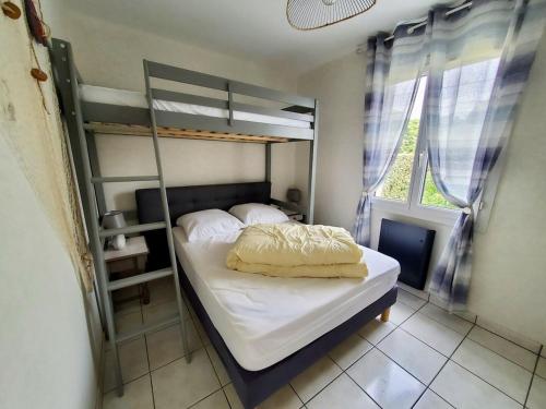 une chambre avec un lit superposé et une fenêtre dans l'établissement Maison moderne 4 pers près du phare de Chassiron avec jardin clos, wifi, et proche plage - FR-1-778-21, à Saint-Denis-dʼOléron