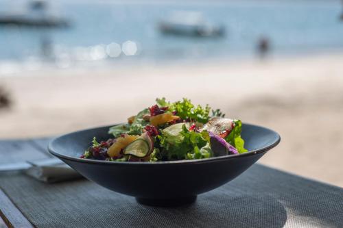 a salad in a black bowl on a table at Los Vivos Beachfront Experience in Pochote