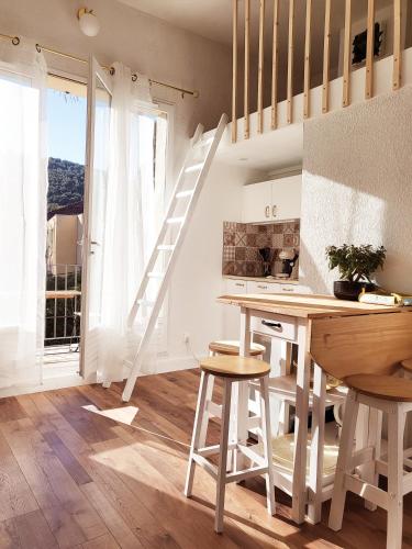 une cuisine avec un escalier, une table et des chaises dans l'établissement La Suite Costabella à Hyères-les-Palmiers, à Hyères
