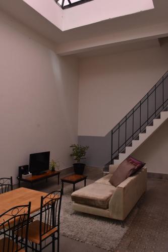 a living room with a couch and a staircase at Morada Montevideana in Montevideo
