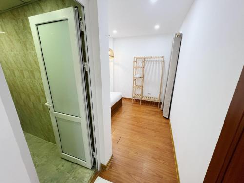 a hallway with a glass door and a room with a bed at Ha Long Homestay in Ha Long