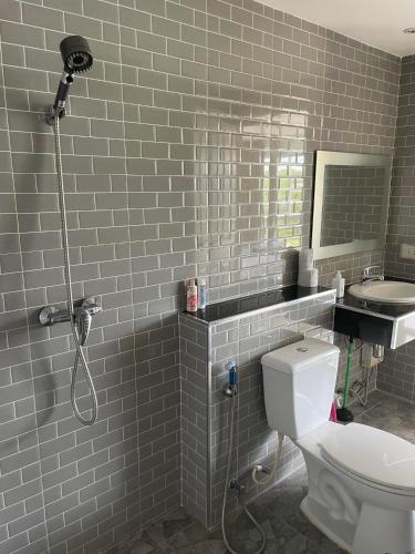 a bathroom with a white toilet and a sink at Bangsaray Beach Resort in Bang Sare