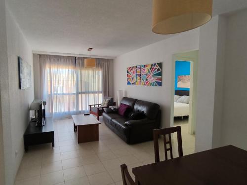 a living room with a black couch and a table at Blue House in Las Palmas de Gran Canaria