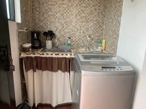 cocina con fregadero y lavadora en OASIS, en Leticia