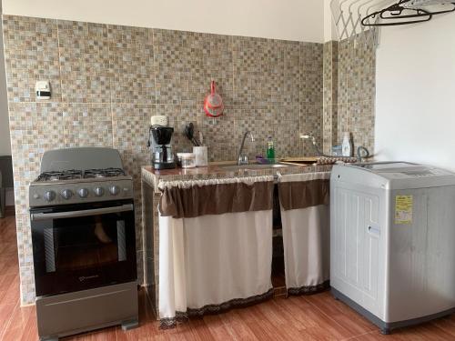 een keuken met een fornuis en een wastafel bij Casa Oasis in Leticia