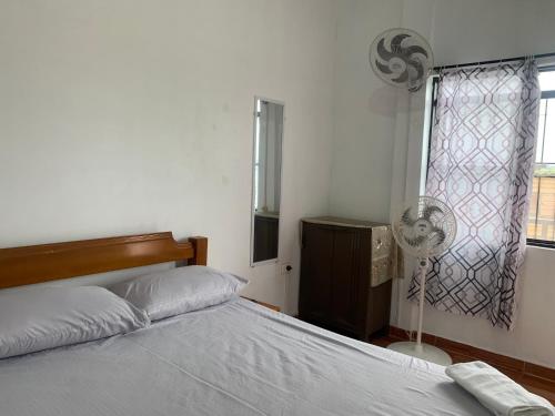 1 dormitorio con 1 cama, ventilador y ventana en OASIS, en Leticia