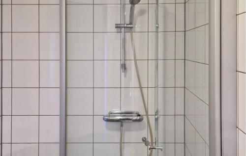 a shower in a bathroom with white tiles at 3 Bedroom Gorgeous Home In Sysslebck in Sysslebäck