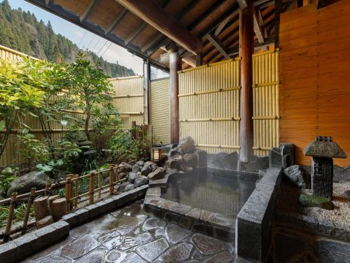 湯布院的住宿－Sanso Matsuya，花园中带围栏的游泳池