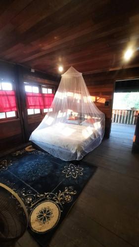 a bed in a room with a mosquito net at Hug Doi Homestay in Ban Wo