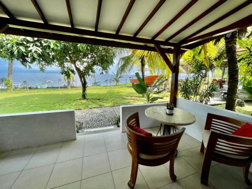 a patio with a table and chairs and a view of the ocean at Tejakula Sunset Boutique Resort in Tejakula