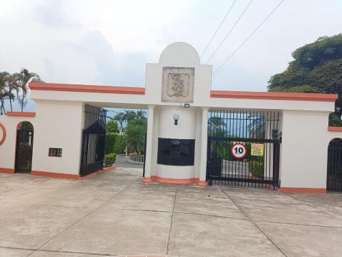 a white and red building with a gate at Apartamento Campestre in Fusagasuga