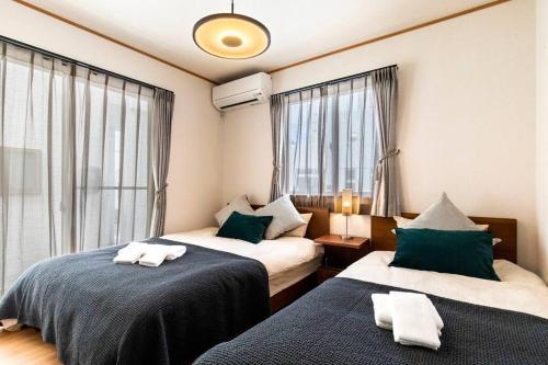 Una cama o camas en una habitación de 沖縄を北から南まで楽しみたい方にピッタリ！近場にはエメラルドグリーンに輝くビーチもあります