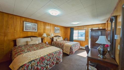 a train room with two beds and a desk with a table at Delta Motel in Bay City