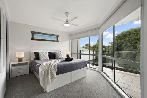 a bedroom with a bed and a balcony at Driftwood Townhouse - Waterfront-Central Location in Lakes Entrance