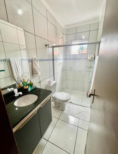 a white bathroom with a sink and a toilet at Apartamento próximo ao Parque do Povo em Campina Grande in Campina Grande