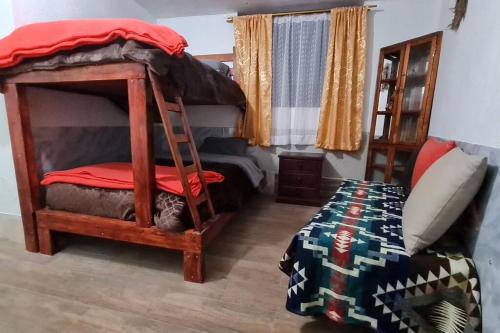 ein Schlafzimmer mit einem Etagenbett mit einer Leiter in der Unterkunft Habitación en Papallacta in Papallacta