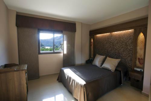 a hotel room with a bed and a window at Hotel La Brasa in Vélez de Benaudalla