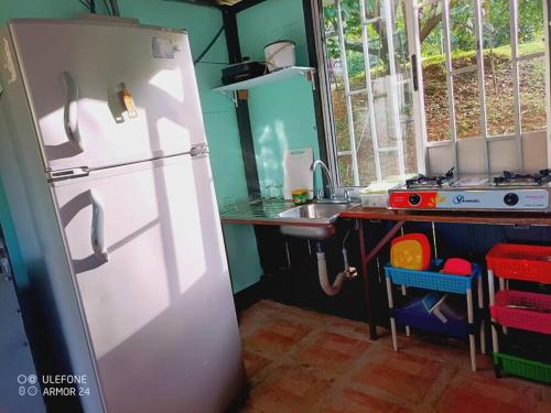 a kitchen with a white refrigerator and a sink at Cabaña en la montaña in Venecia