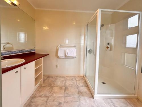 a bathroom with a shower and a sink at Tutukaka Dive Lodge in Tutukaka